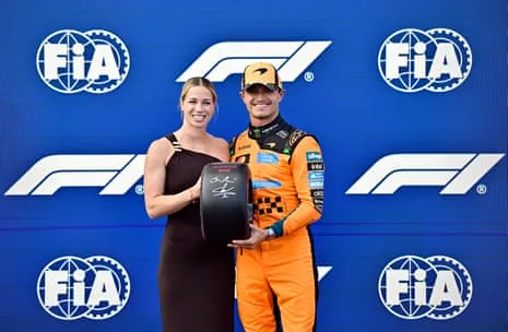 McLaren’s Lando Norris celebrates with a trophy after qualifying in pole position.