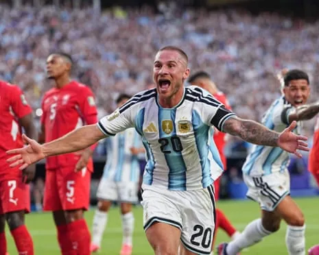 Alexis Mac Allister in Argentina's striped jersey celebrates with arms outstretched and mouth open