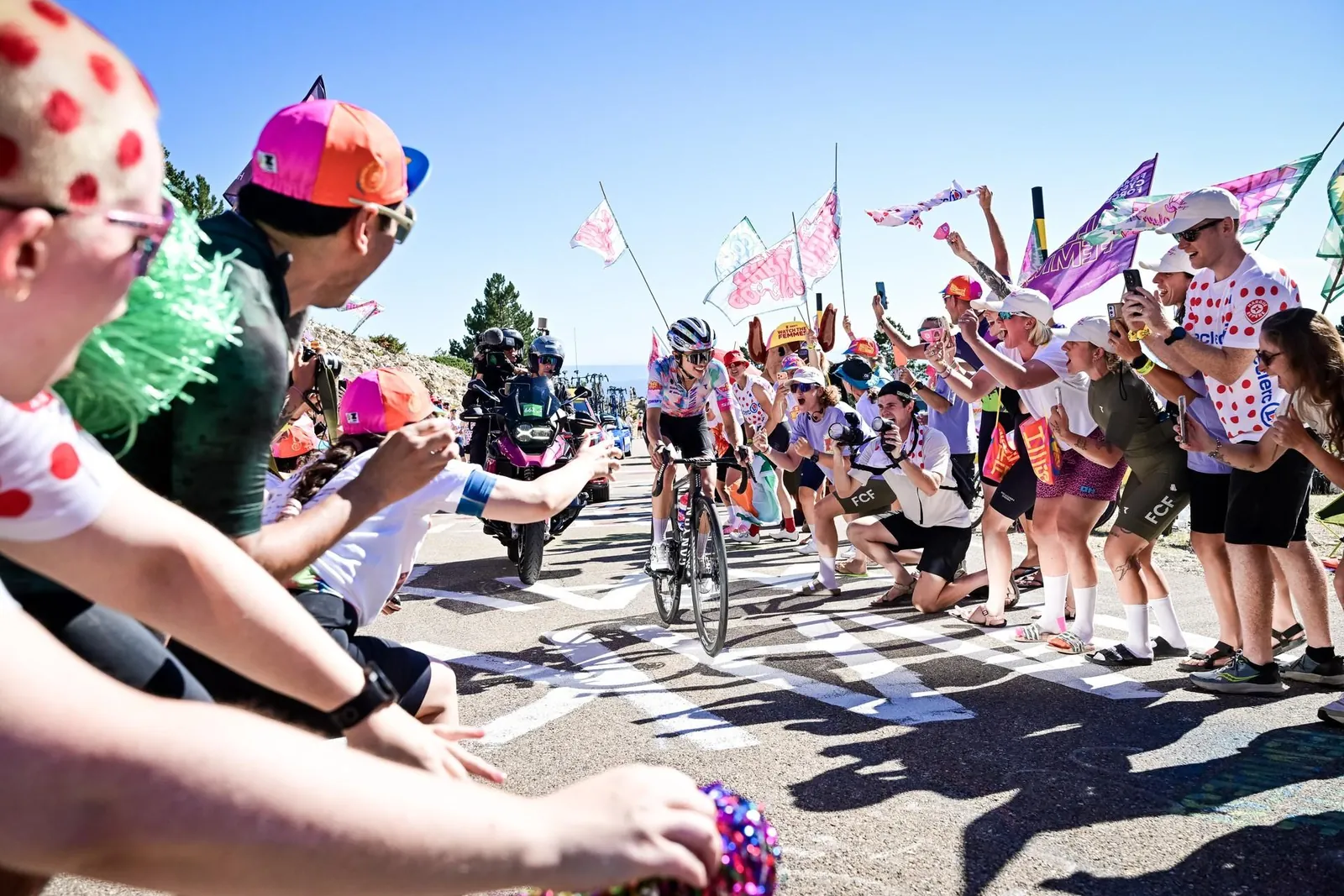 Cyclist Katarzyna Niewiadoma-Phinney in rainbow jersey rides past cheering fans during Tour de France Femmes